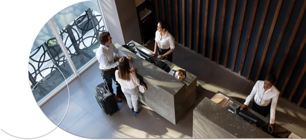 an aerial view of a hotel concierge with two hotel employees and two guests