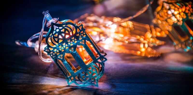 a blue and a yellow lantern lit up resting on a table